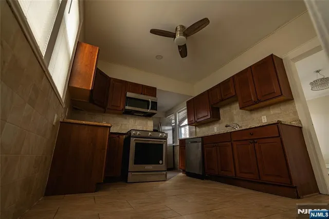 a kitchen with stainless steel appliances granite countertop a refrigerator and a sink