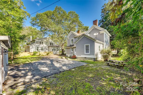 a view of a house with backyard and a tree