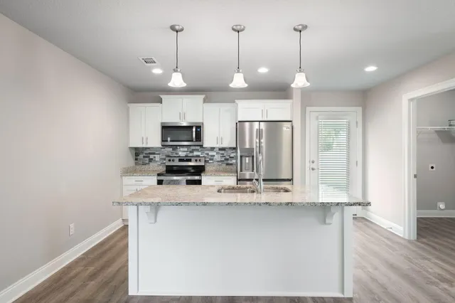 a kitchen with granite countertop stainless steel appliances and wooden cabinets