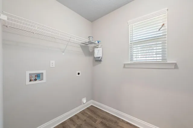 an empty room with a chandelier fan and windows