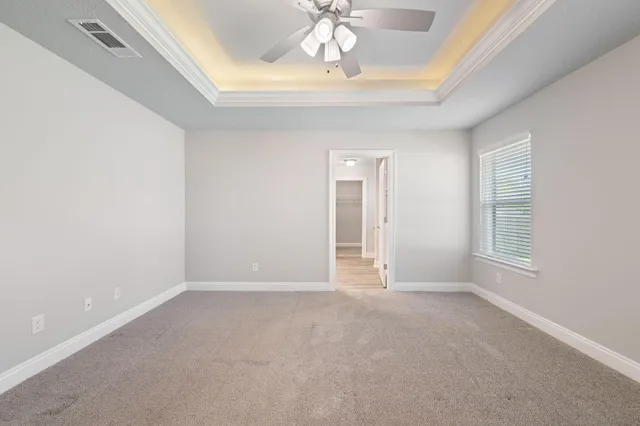 an empty room with a window and a fan