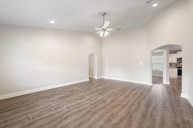 a view of empty room with wooden floor