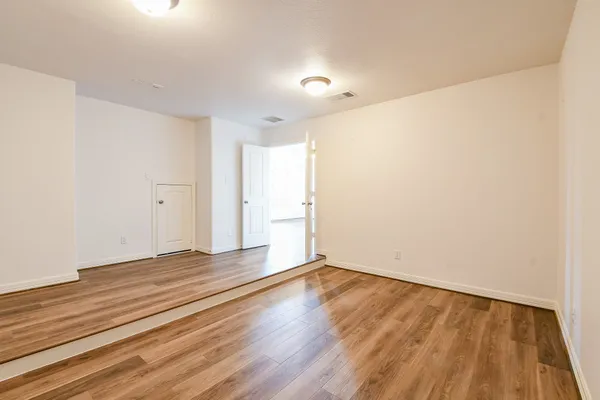 a view of an empty room with wooden floor