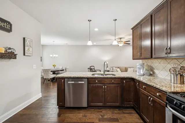 a kitchen with a sink a counter space appliances and cabinets