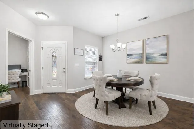 a view of a dining room with furniture wooden floor and chandelier