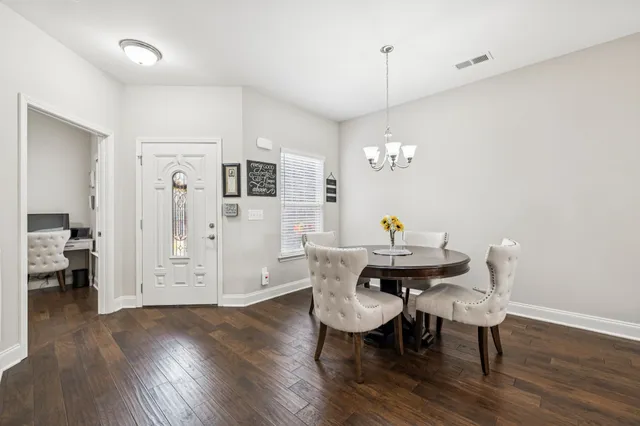 a view of a dining room with furniture wooden floor and chandelier