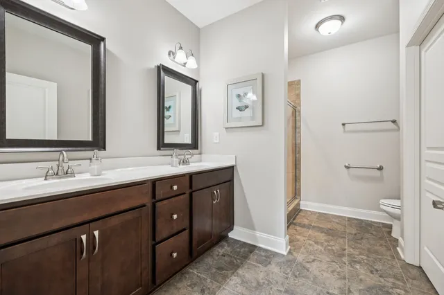 a en suite bathroom with a double vanity sink and a mirror