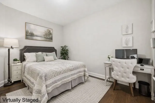 a bedroom with a bed a chair and a computer on a table