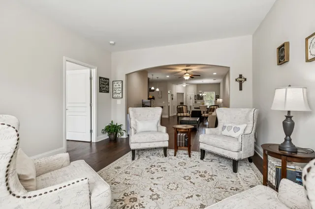 a living room with furniture and a large mirror next to a window