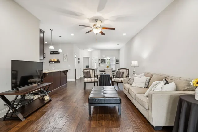 a living room with furniture a flat screen tv and kitchen view