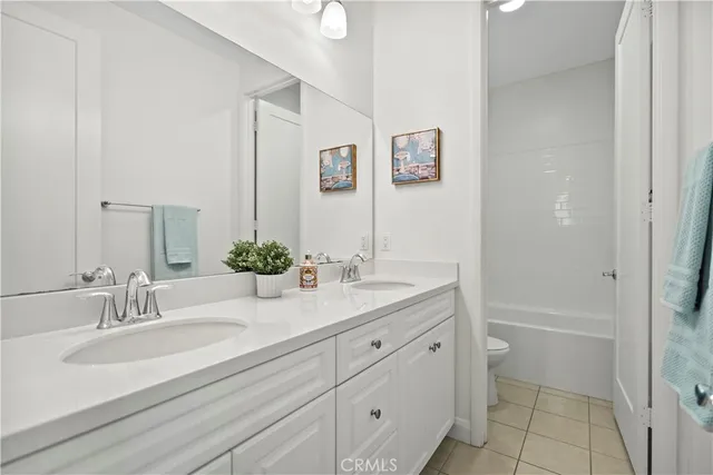 a bathroom with a granite countertop sink a toilet and a mirror