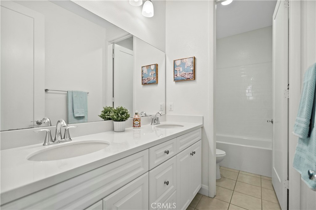 6670 Meadowlane Place Rancho Cucamonga, CA 91701 - Photo 17 of 26 a bathroom with a granite countertop sink a toilet and a mirror