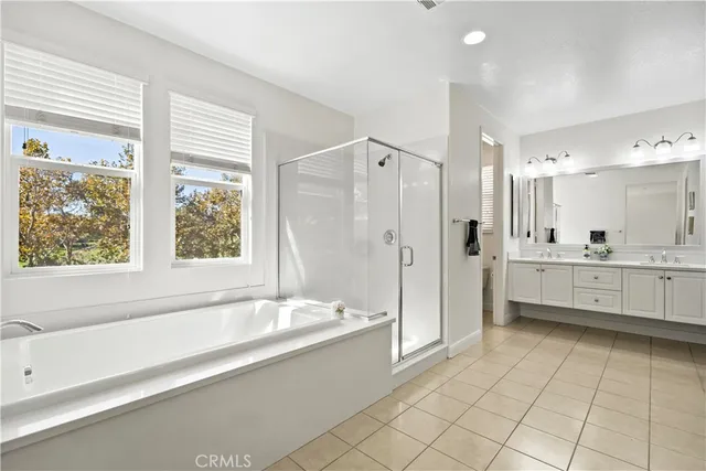 a bathroom with a tub shower vanity and sink