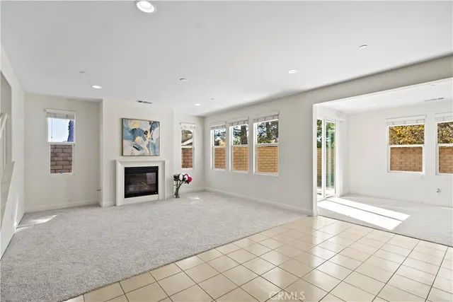 a view of an empty room with a fireplace and a window