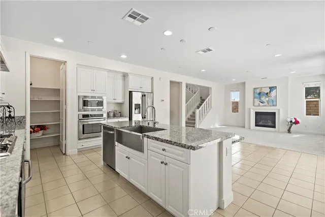 a kitchen with stainless steel appliances granite countertop a refrigerator and a sink