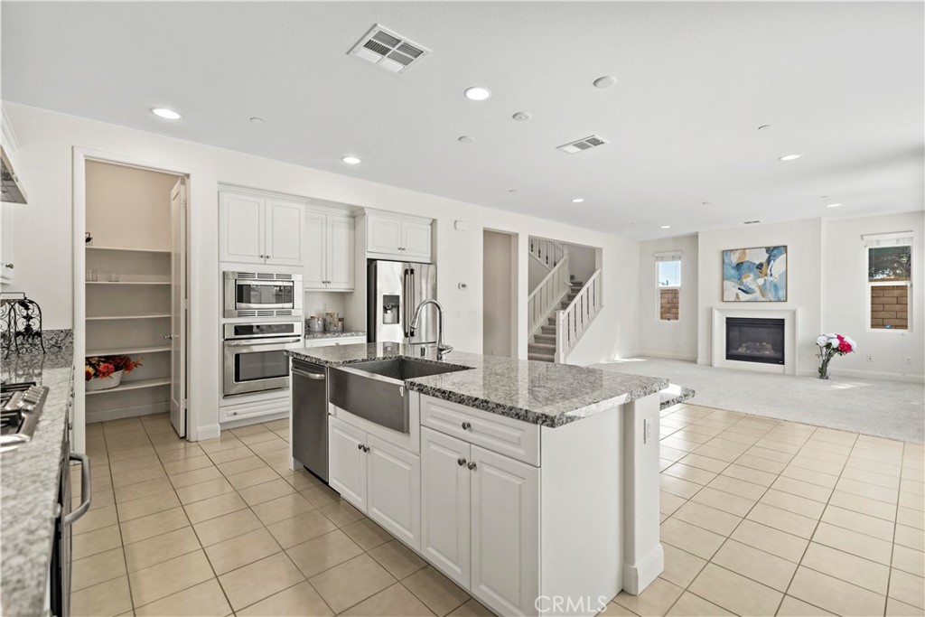 6670 Meadowlane Place Rancho Cucamonga, CA 91701 - Photo 8 of 26 a kitchen with stainless steel appliances granite countertop a refrigerator and a sink