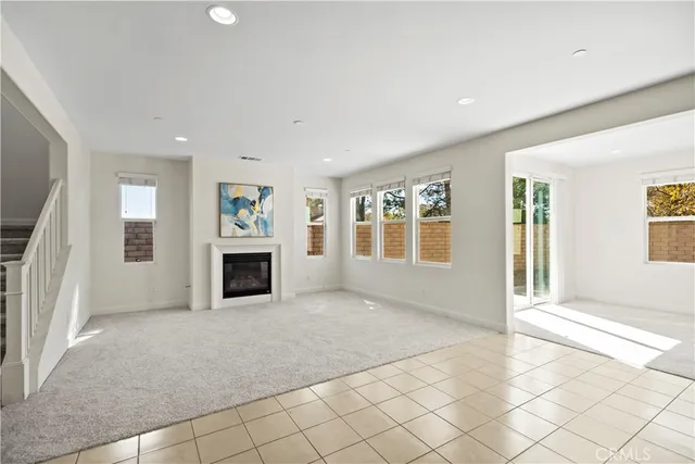 a view of an empty room with a fireplace and a window