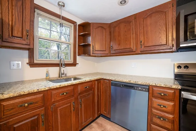a kitchen with granite countertop cabinets sink and window