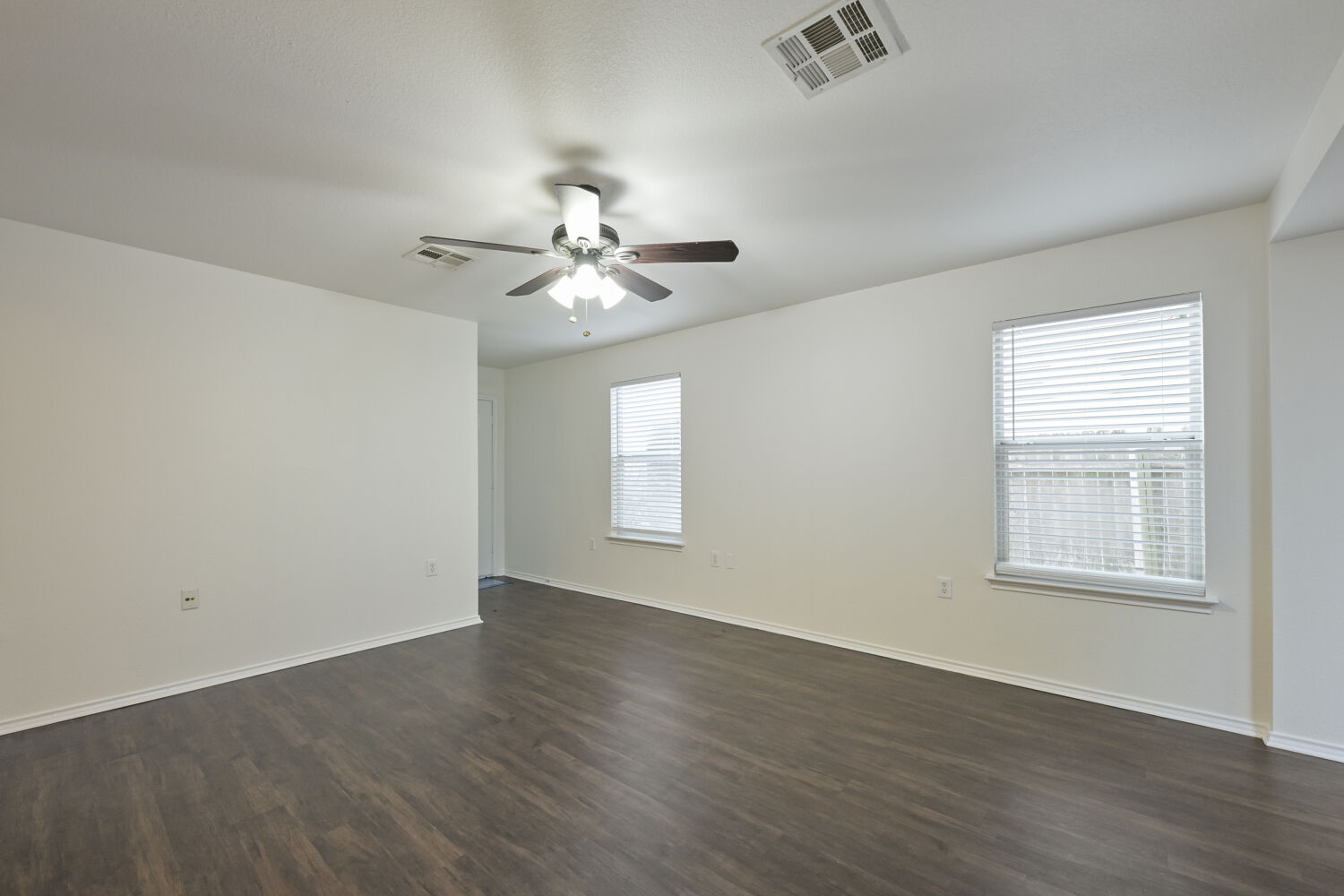 6733 Doyal Drive Austin, TX 78747 - Photo 5 of 28 A spacious room offers comfortable living with warm wood flooring and ample natural light.