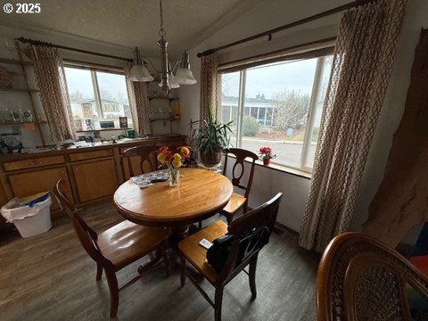 1199 North Terry Street, Unit 139 Eugene, OR 97402 - Photo 11 of 23 a dining room with furniture a chandelier and wooden floor