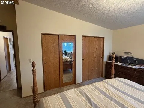 a bedroom with a bed and a refrigerator