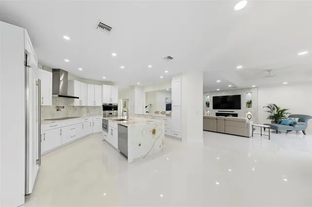 a kitchen with stainless steel appliances kitchen island granite countertop a stove a sink and a refrigerator