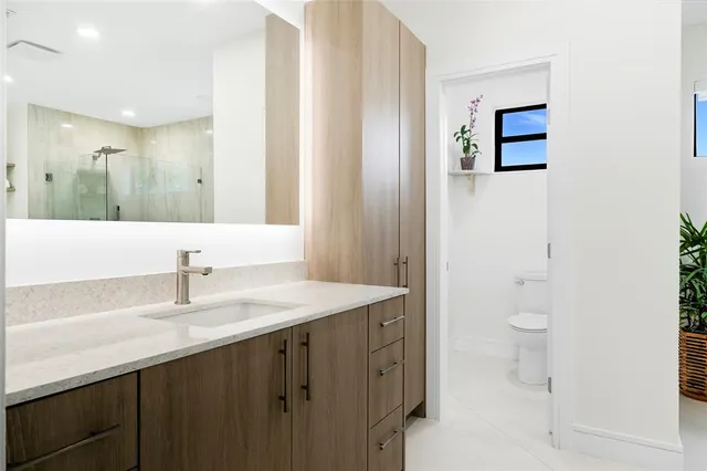 a bathroom with a double vanity sink toilet and shower