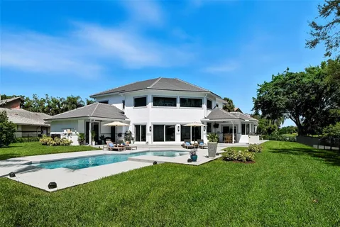 a front view of a house with a garden and trees
