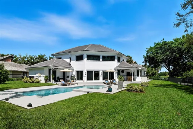 a front view of a house with a garden and trees