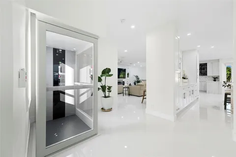 a living room with furniture a clock on wall and a flat screen tv