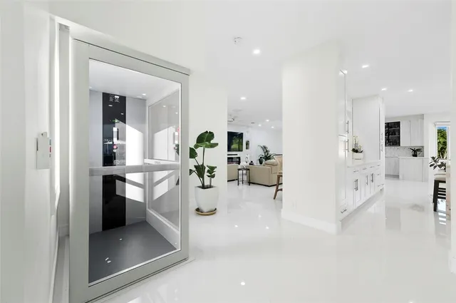 a living room with furniture a clock on wall and a flat screen tv