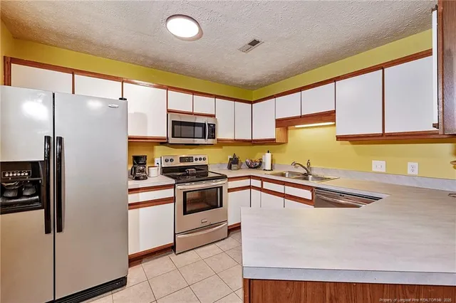 a kitchen with stainless steel appliances granite countertop a sink stove and microwave