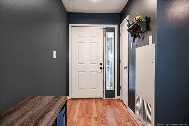a view of a hallway with wooden floor and closet