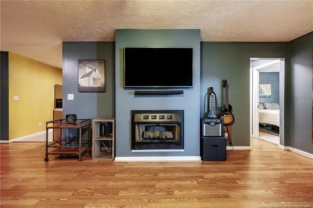 a living room with furniture a flat screen tv and a fireplace