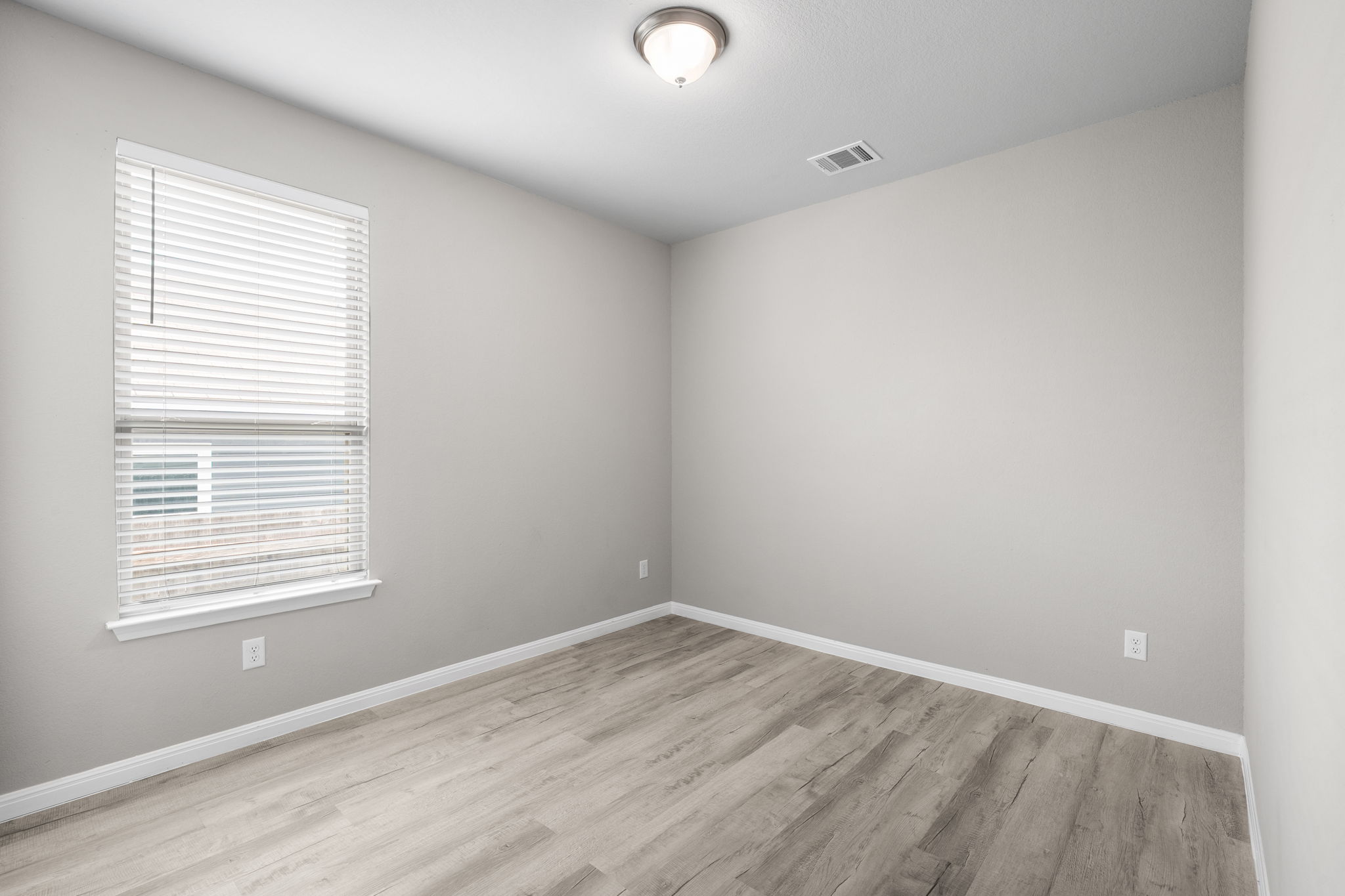313 Mclintock Road Jarrell, TX 76537 - Photo 11 of 40 A well-lit, versatile room with elegant wood flooring and a single window.