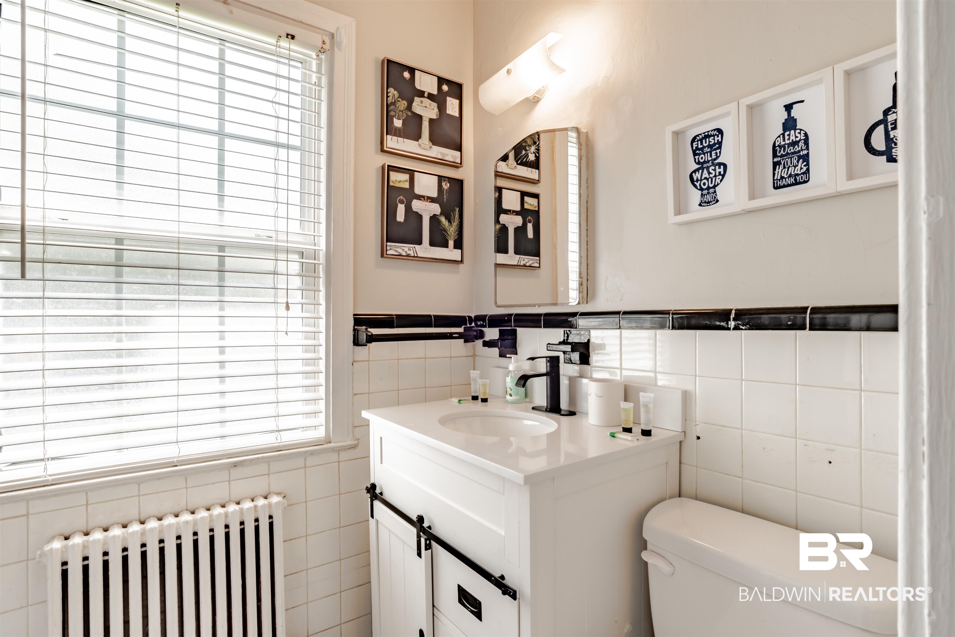 214 Upham Street, Unit 7C Mobile, AL 36607 - Photo 14 of 32 Half bath featuring radiator heating unit, vanity, tile walls, and healthy amount of natural light