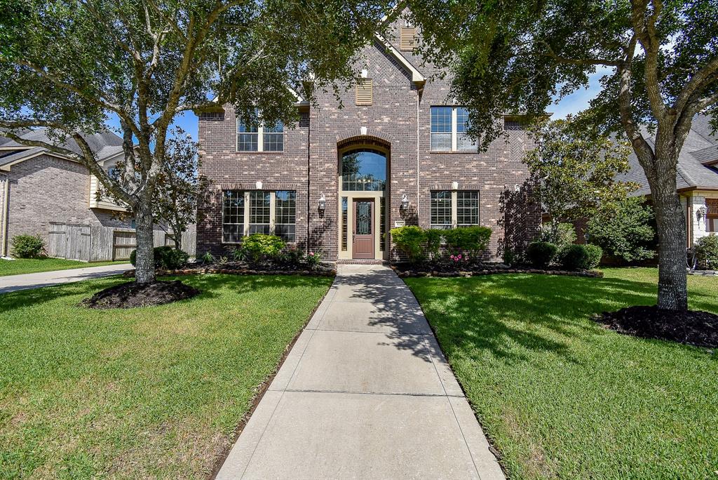 Extra wide front walk leads you to the beautiful Texas Star leaded glass front door of this Trendmaker Home!  Great trees for shade and lush landscaping.