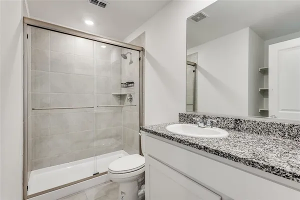 a bathroom with a granite countertop sink toilet and shower