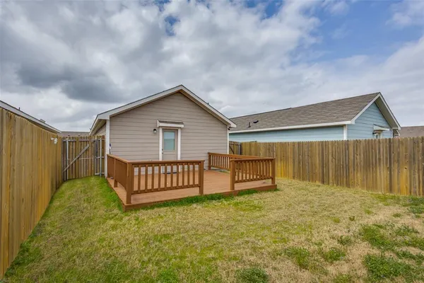 a view of a house with backyard and wooden fence