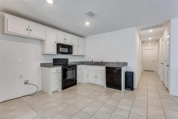 a kitchen with granite countertop a stove top oven and cabinets