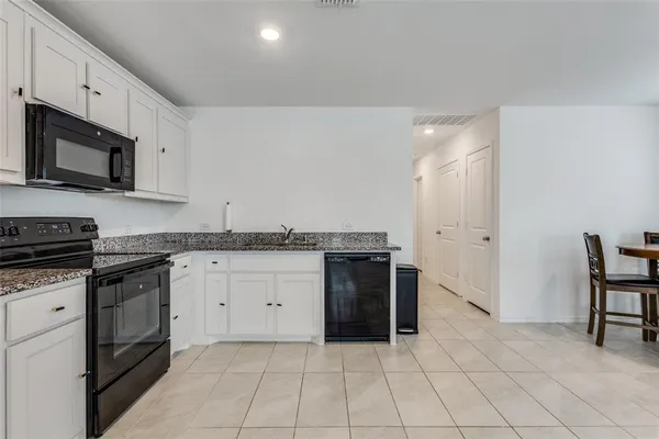 a kitchen with granite countertop a sink and a stove top oven