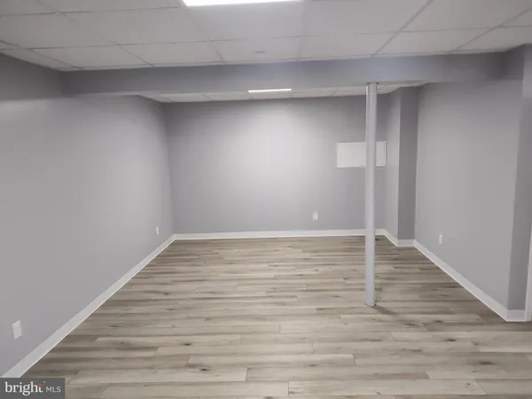 a view of an empty room with wooden floor and closet