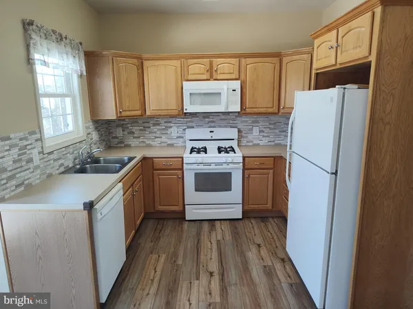 a kitchen with a refrigerator sink and cabinets