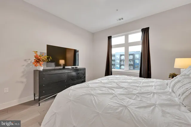 a living room filled with furniture hardwood floor and a large window