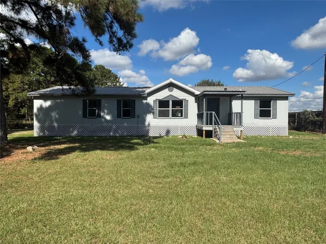 a front view of house with yard and trees
