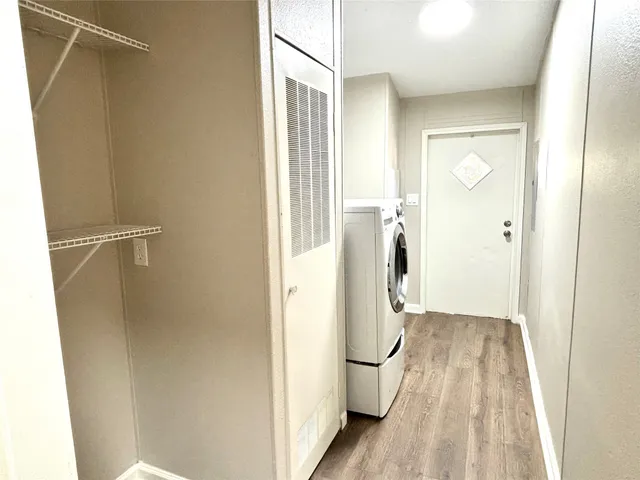 a view of walk in closet with wooden floor