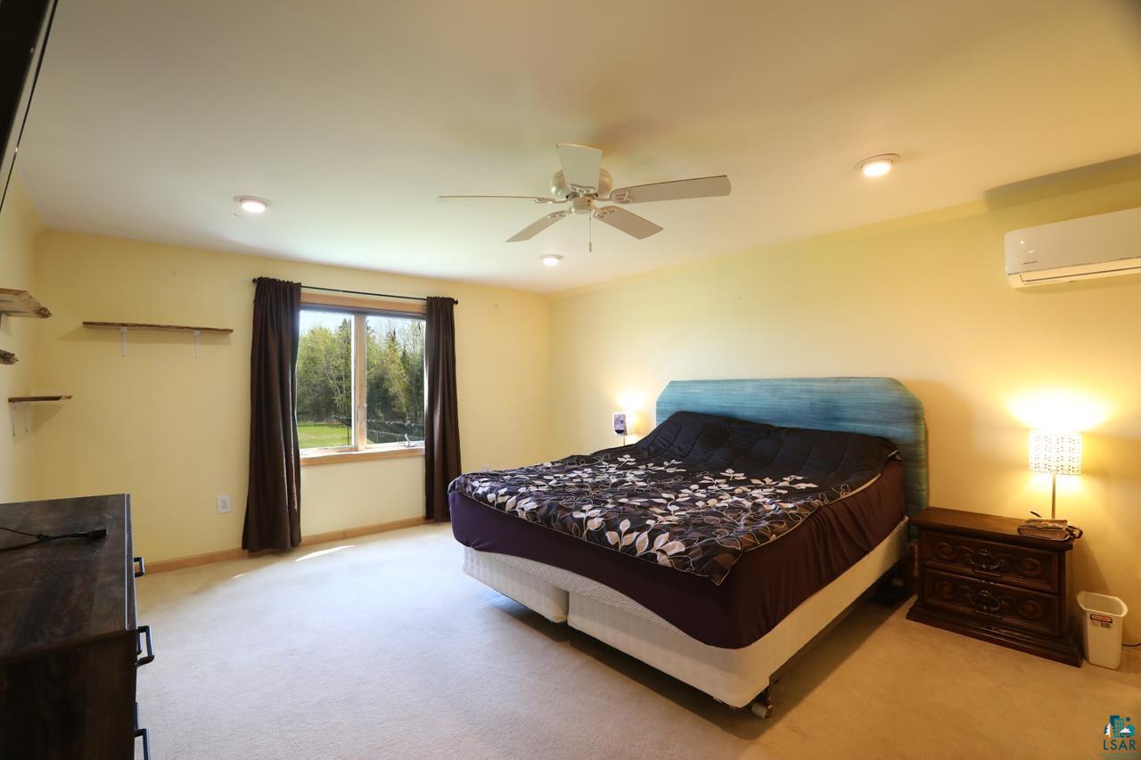 10362 Arkola Road Meadowlands, MN 55765 - Photo 14 of 30 Carpeted bedroom with a wall mounted air conditioner, baseboards, recessed lighting, and ceiling fan
