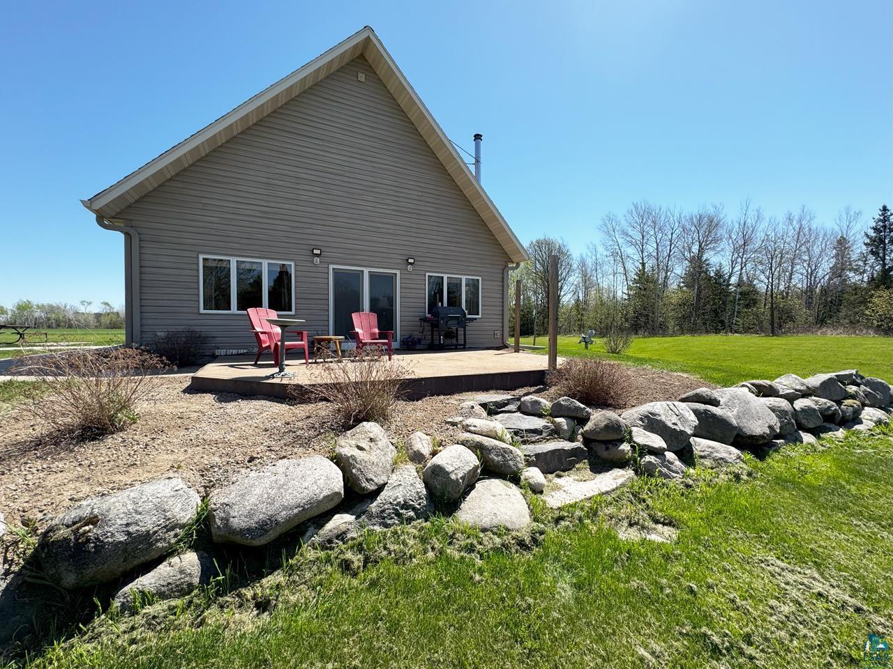10362 Arkola Road Meadowlands, MN 55765 - Photo 23 of 30 Back of property with a lawn and a patio