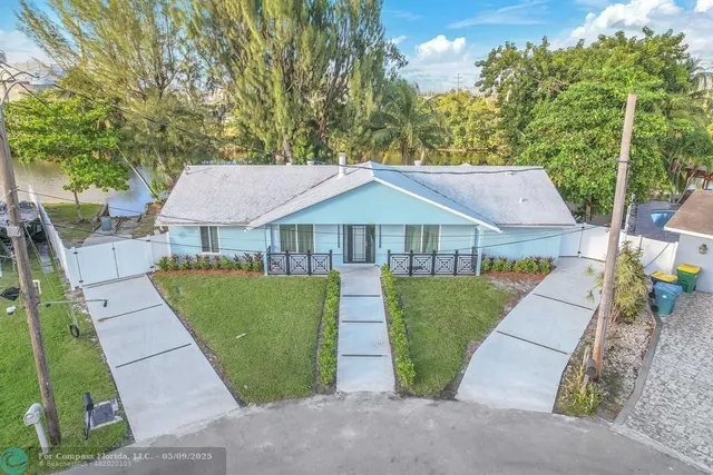 a view of house with garden and tall trees