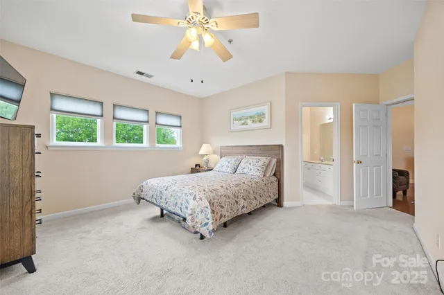 a spacious bedroom with a bed and a chandelier
